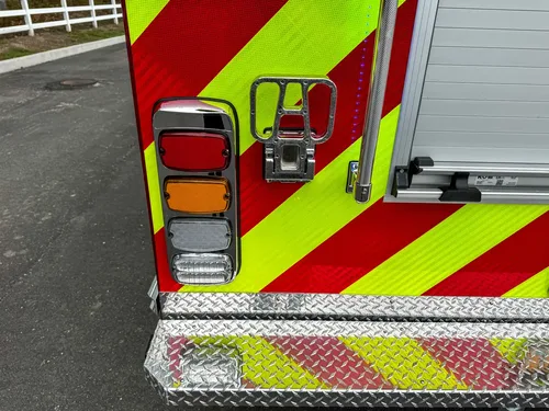 Rear-center chevron close-up with closed roll-up door and bumper edge.
